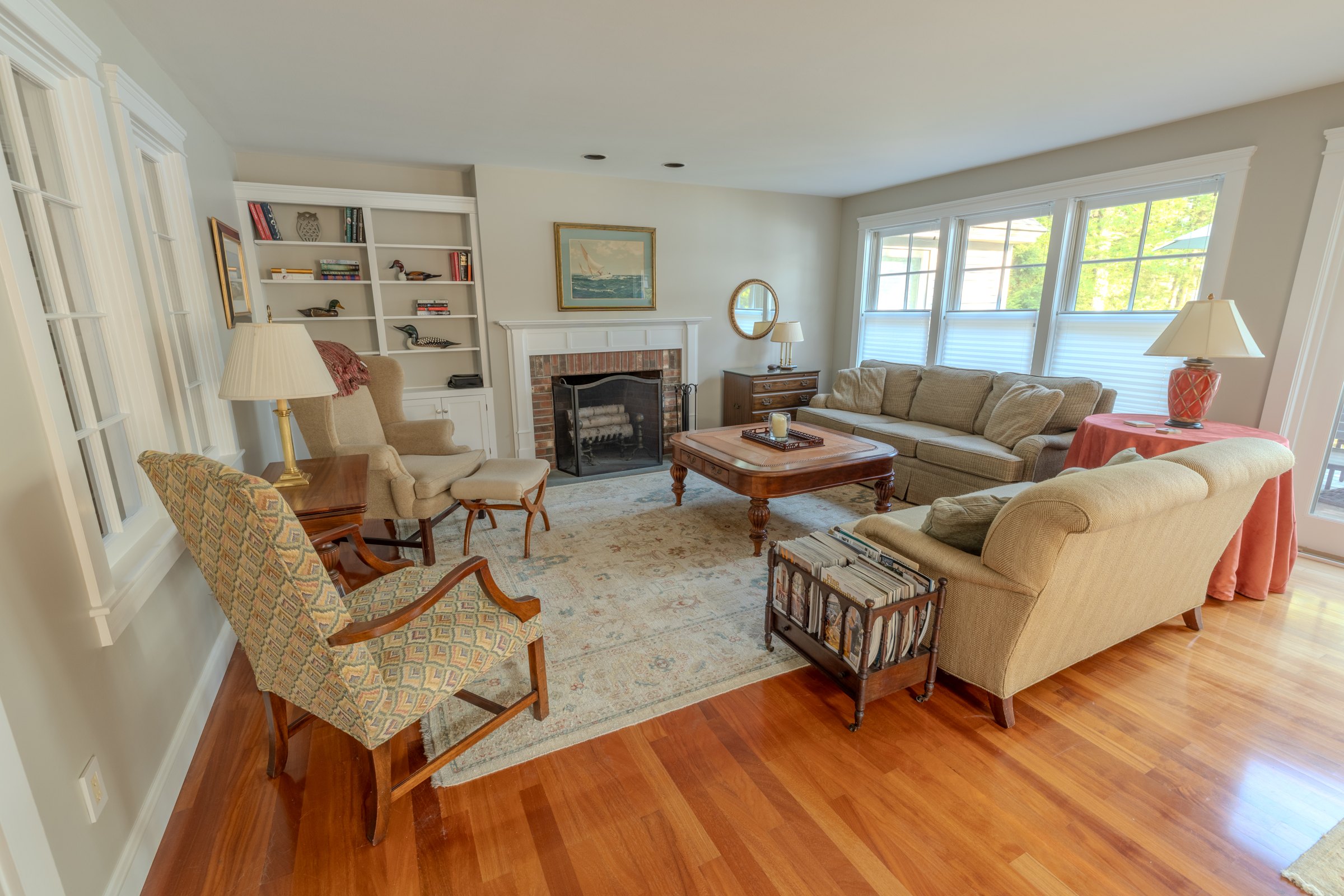 Bright Woodland sitting room with fireplace, bookshelves and upholstered seating